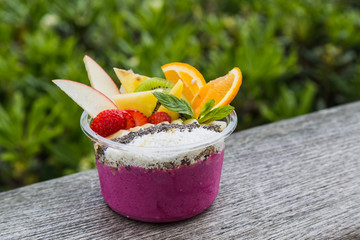 Vibrant takeaway acai bowl with fresh fruit and mint