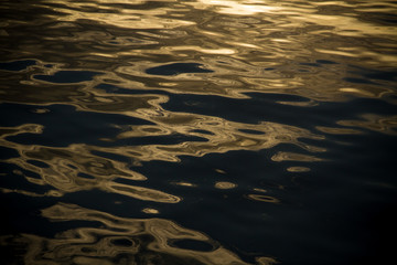 The water ripples reflection sunset lights on the ocean water surface	