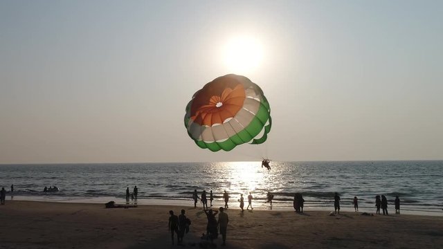 Takeoff a parachute on the beach at beautiful sunset in counter light. Aerial view.
