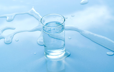 water in glass put on table under the blue sky reflection for healthy or drink, nature concept.
