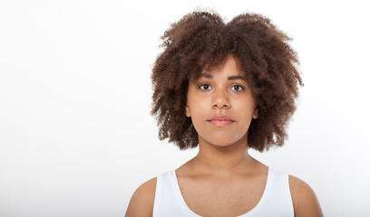 Portrait of beautiful black woman isolated. Atractive brunette dark-skinned woman in a white tank top.