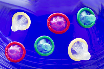 Condoms green, red and white on blue background