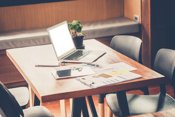 Business concept. Office supply on desk table with analysis chart, smartphone, laptop,pencil and flower vase at workplace.