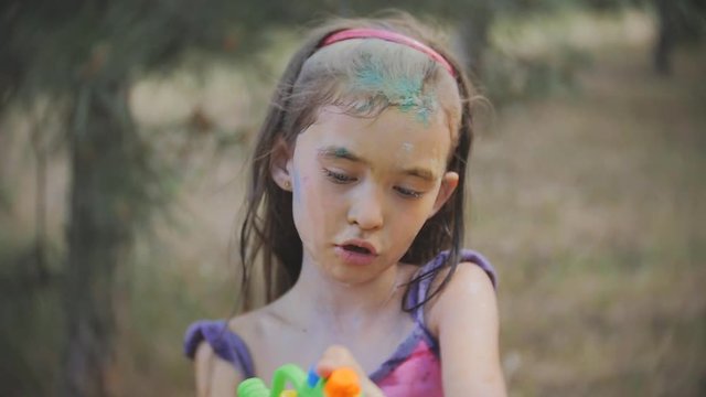 little girl covered in paint after Holi festival throw water