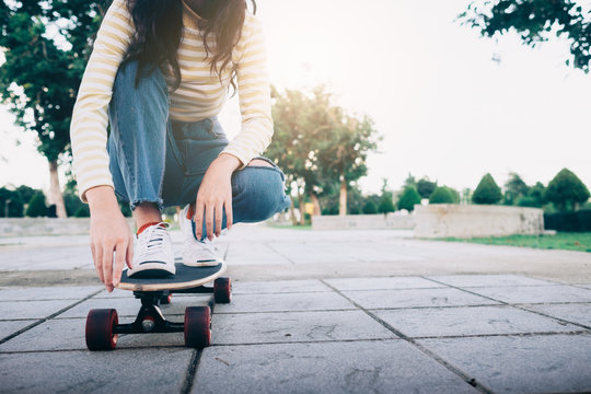 Young teen girl on longboard in the city.