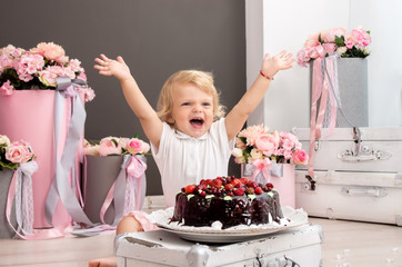 happy little blonde girl with birthday chocolate berry cake