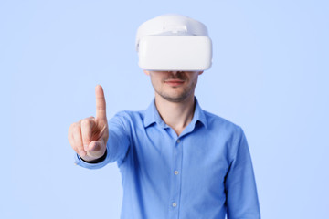 Into virtual reality world. Man wearing goggle headset, clicks his finger on the virtual button 3D...