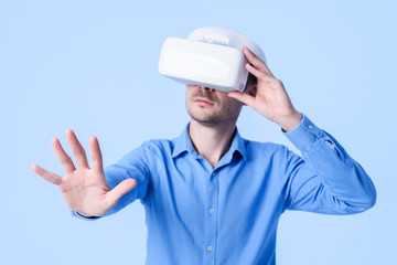 Into virtual reality world. Man wearing goggle headset. Future technology. 3D rendering. Studio shot, blue background
