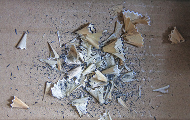Pencil shavings from black and white color print pencil, they are on pastel floor.