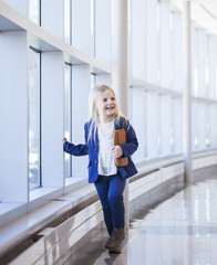 Portrait of happy little blond child walking in office hall