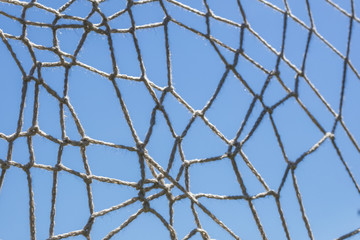 A crocheted web of thread against the blue sky. Background, texture