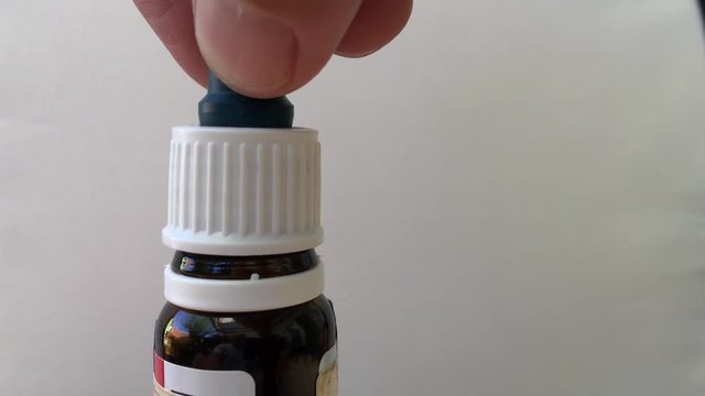 Medical pipette dropping liquid ear drops, macro shot