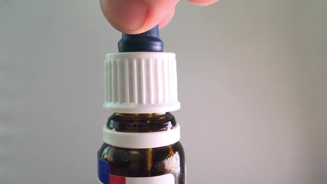 Medical pipette dropping liquid ear drops, macro shot