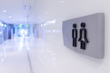 Men and women toilet signs on wall, black and gray