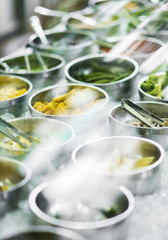 Obraz na płótnie Canvas bowls of mixed fresh organic vegetables in salad bar display