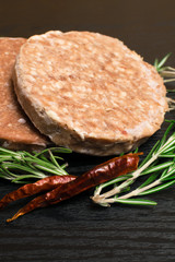 Raw Minced burger Meat with Herb and Spice Prepared for Grilling with rosemary, hot red chili, black pepper