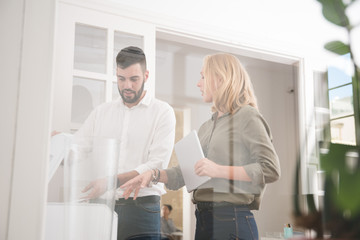Business colleagues standing around the copier