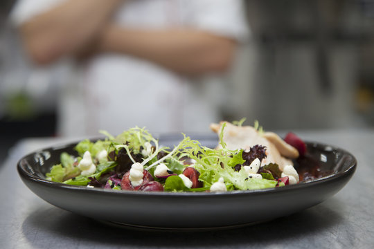 The cook prepares a salad with cherries