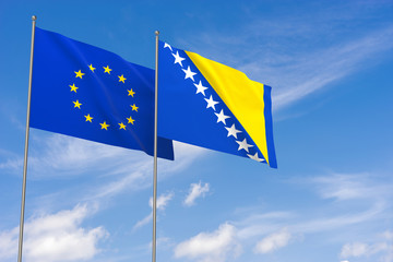 European Union and Bosnia and Herzegovina flags over blue sky background.