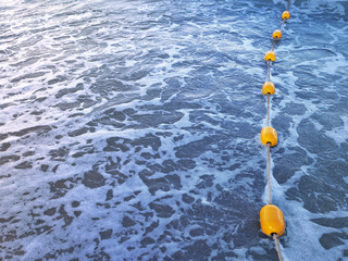 Yellow buoys line in blue water