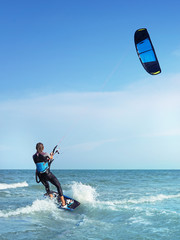 Woman on board on wave kiting in the ocean