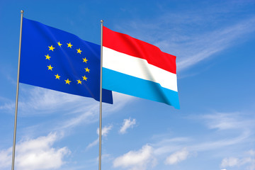 European Union and Luxembourg flags over blue sky background.