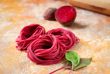 hand made beetroot pasta nest on a wooden table