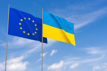 European Union and Ukraine flags over blue sky background.