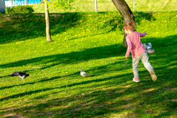Funny child in glasses playing in a summer park.