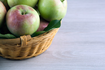 fresh apples in the basket on a gray wooden background