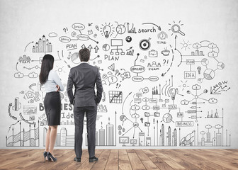 Business partners looking at wall, business plan