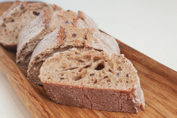 Buckwheat bread with flax seeds on an oak plate. Candid.