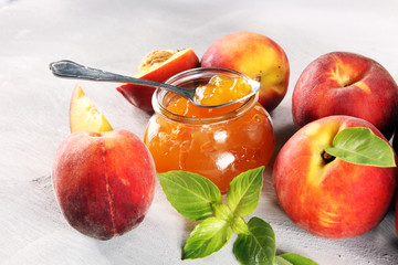 Peach vanilla jam with fresh peaches on table.
