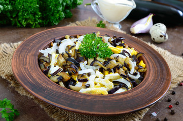 Spicy salad of fried eggplant, boiled egg, marinated onions in a bowl.