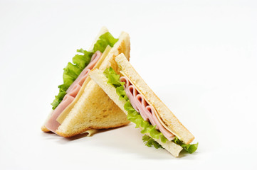 Two triangular sandwiches with cheese and ham. The sandwich is made from slices of fried white bread. Close-up. White background.