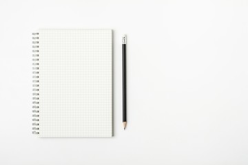 grid paper book and pencil on a white desk - for business concept background