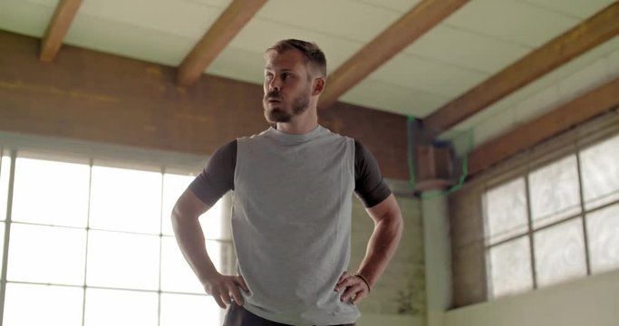 Tired young adult man resting in recovering pause portrait during fitness sport workout .Grunge industrial urban training.4k slow motion video