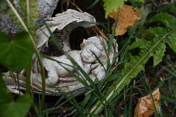 A nearly hidden sandstone sculpture of a sleeping angel. 