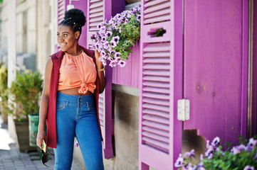 African american girl posed against purple windows outdoor.