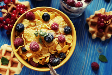 Healthy breakfast. Corn flakes with raspberries and blueberries, granola with yogurt and berries, wafers and milk. A great start to the day. Top view.