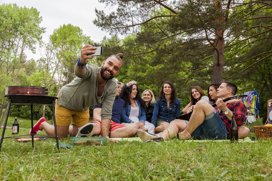 freunde genießen ihren ungezwungenen lebensstil beim grillen im park und machen ein gruppen selfie foto.