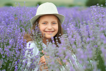child girl is in the lavender field, beautiful portrait, face closeup, summer landscape