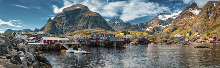 Panoramic shot of A village, Moskenes, on the Lofoten in northern Norway. Norwegian fishing village, with the typical rorbu houses.  Mountain In Background - obrazy, fototapety, plakaty