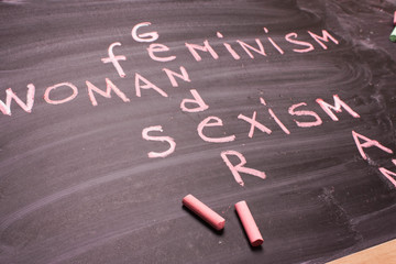 Words gender, sexism, feminism written in pink chalk