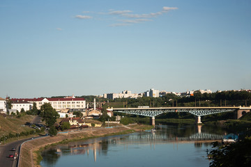 Fototapeta na wymiar Sights and views of Grodno. Belarus. The Neman River, flowing through the city, buildings along the banks and a bridge across the river.