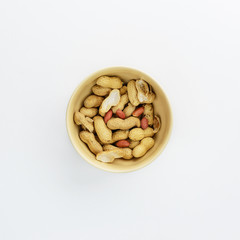 Cup with peanuts on white background
