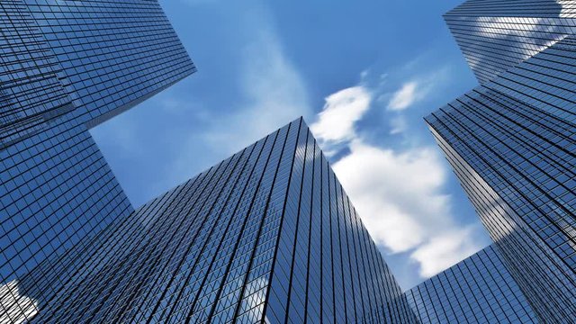 Clouds moving over glass buildings.