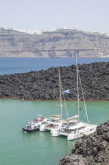 Fototapeta na wymiar Ccatamarans on port of Nea Kameni volcanic island near Santorini