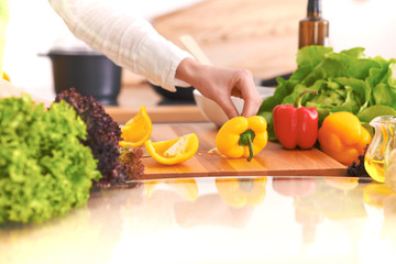 Close Up of human hands cooking vegetable salad in kitchen on the glass table with reflection. Healthy meal, and vegetarian food concept