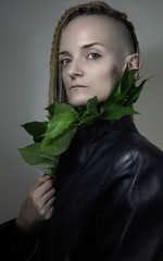 Portrait of an Elf Girl. Nature Protection. Model's Face with pale skin and green leaves near her...